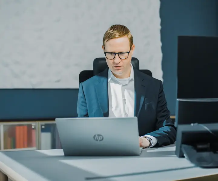 Wachstumschancengesetz-sbp Ein Mann sitzt am Schreibtisch an einem Laptop